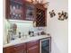 Wet bar area with wood cabinets, wine cooler, granite counter and beverage accessories at 3723 Belle Rose Dr, Leesburg, FL 34748
