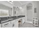 Bright bathroom featuring double vanity, marble floors, and walk-in shower with classic white subway tile at 4060 Longbow Dr, Clermont, FL 34711