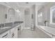 Bright bathroom with double vanity, arched shower, and soaking tub beneath window at 4060 Longbow Dr, Clermont, FL 34711