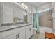 Bright bathroom with double sink vanity, shower, tub, and white cabinets at 4060 Longbow Dr, Clermont, FL 34711