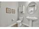 Powder room featuring a pedestal sink, toilet, and decor at 4060 Longbow Dr, Clermont, FL 34711