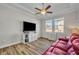 Bright living room features wood floors, white storage, large TV, and a comfy red leather sofa at 4060 Longbow Dr, Clermont, FL 34711
