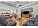 Open-concept living room with a large TV, comfortable seating, and access to the kitchen at 4060 Longbow Dr, Clermont, FL 34711
