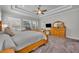 Spacious main bedroom featuring carpeted floors, tray ceilings, and natural wood furniture at 4060 Longbow Dr, Clermont, FL 34711