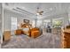 Spacious main bedroom with natural wood furniture, tray ceiling, ceiling fan, and large windows at 4060 Longbow Dr, Clermont, FL 34711
