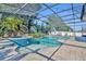 Gorgeous screened pool with attached spa and tropical landscaping, creating a serene backyard oasis at 4060 Longbow Dr, Clermont, FL 34711