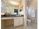 Bathroom featuring a walk-in shower, large mirror, vanity with storage, and neutral decor at 4387 Sambourne St, Clermont, FL 34711