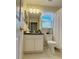 Well-lit bathroom featuring a white vanity, toilet, and a window for natural light at 4387 Sambourne St, Clermont, FL 34711