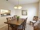 Inviting dining area featuring a wooden table, natural lighting, and a view to the adjacent kitchen area at 4387 Sambourne St, Clermont, FL 34711