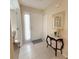 Inviting entryway featuring tile flooring, a decorative table, and a sidelight window beside the front door at 4387 Sambourne St, Clermont, FL 34711
