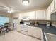 Bright kitchen featuring white cabinets, tile flooring, and a cozy breakfast nook with decorative table and chairs at 4387 Sambourne St, Clermont, FL 34711