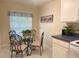Cozy breakfast nook area with stylish table and chairs with kitchen cabinets and appliances in the background at 4387 Sambourne St, Clermont, FL 34711