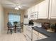 Bright kitchen featuring white appliances, white cabinets and breakfast nook area with stylish table and chairs at 4387 Sambourne St, Clermont, FL 34711