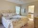 Bedroom featuring a comfortable floral patterned bed, ensuite bathroom, ceiling fan and neutral decor at 4387 Sambourne St, Clermont, FL 34711