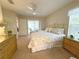 Bedroom featuring a comfortable floral patterned bed, ceiling fan and two dressers at 4387 Sambourne St, Clermont, FL 34711