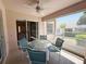 Screened patio with a round glass table, seating, ceiling fan and a view of the outdoors at 4387 Sambourne St, Clermont, FL 34711