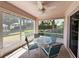 Screened patio featuring a round glass table, seating, ceiling fan and a view of the outdoors at 4387 Sambourne St, Clermont, FL 34711