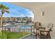A relaxing balcony view of the pool and manicured grounds with swaying palm trees on a clear day at 4841 Saxon Dr # E206, New Smyrna Beach, FL 32169