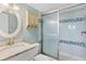 Tiled bathroom with glass shower door and ample lighting at 4841 Saxon Dr # E206, New Smyrna Beach, FL 32169