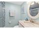 Bright bathroom featuring a granite vanity, tile shower with blue accents, and coastal themed decor at 4841 Saxon Dr # E206, New Smyrna Beach, FL 32169