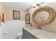 Well-lit bathroom with granite countertop and decorative mirror at 4841 Saxon Dr # E206, New Smyrna Beach, FL 32169