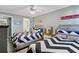 This coastal bedroom features two beds with striped bedding, beach decor, and a ceiling fan at 4841 Saxon Dr # E206, New Smyrna Beach, FL 32169