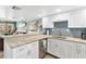 An open kitchen features a granite countertop, stainless steel dishwasher, and views of the living room and balcony at 4841 Saxon Dr # E206, New Smyrna Beach, FL 32169