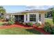 The home features a screened-in patio and a beautifully landscaped yard with red mulch and lush greenery at 4972 Big Cypress St, Oxford, FL 34484