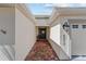 Front entryway with brick-paved walkway leading to a dark front door and white exterior at 4972 Big Cypress St, Oxford, FL 34484