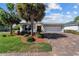 Charming single-story home with a brick driveway, mature landscaping, and a two-car garage at 4972 Big Cypress St, Oxford, FL 34484