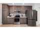 Well-equipped kitchen with stainless steel appliances, dark cabinets, and light countertops at 4972 Big Cypress St, Oxford, FL 34484
