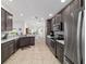 Spacious kitchen featuring dark wood cabinets, granite countertops, and stainless steel appliances at 4972 Big Cypress St, Oxford, FL 34484