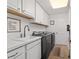 White laundry room with plenty of counter space, cabinet space and new appliances at 4972 Big Cypress St, Oxford, FL 34484