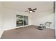 Screened porch with a wicker chair and view to the backyard with green shrubs and grass at 4972 Big Cypress St, Oxford, FL 34484