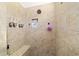 Walk-in shower featuring tan tiling, built in bench, and shower fixtures at 4972 Big Cypress St, Oxford, FL 34484