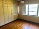 Empty bedroom with wood floors, trim, baseboards and one window at 504 S 12Th St, Leesburg, FL 34748