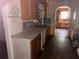Outdated kitchen featuring wood cabinets, double basin sink, and tile backsplash at 504 S 12Th St, Leesburg, FL 34748
