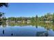 Scenic lake view with calm waters surrounded by lush greenery and clear blue sky at 504 S 12Th St, Leesburg, FL 34748