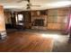 Spacious living room with hardwood floors, fireplace, ceiling fan, and built-in bookshelves at 504 S 12Th St, Leesburg, FL 34748