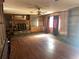 Large living room with a fireplace, wood paneling, and ample natural light at 504 S 12Th St, Leesburg, FL 34748