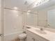 Bright bathroom features a shower-tub combo, a large mirror, and vanity with a sink at 5340 Edgewater Way # 1, Oxford, FL 34484
