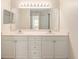 Bathroom with large mirror over double sink vanity and ample lighting at 5340 Edgewater Way # 1, Oxford, FL 34484