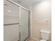 Bathroom featuring white tiled shower with glass door and neutral walls at 5340 Edgewater Way # 1, Oxford, FL 34484