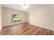 Bright bedroom featuring wood-look flooring, neutral walls, and a window offering green outdoor views at 5340 Edgewater Way # 1, Oxford, FL 34484