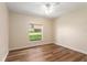 Bedroom featuring wood-look flooring, a ceiling fan, and a window offering green outdoor views at 5340 Edgewater Way # 1, Oxford, FL 34484