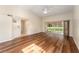 Open-concept living room boasts hardwood flooring, vaulted ceilings, and sliding glass doors to a covered patio at 5340 Edgewater Way # 1, Oxford, FL 34484