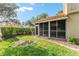 Screened patio with a red tile roof surrounded by grass and trimmed hedges at 5340 Edgewater Way # 1, Oxford, FL 34484