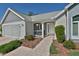 Inviting front porch featuring white railings, brick accents, lush landscaping, and a welcoming walkway to the front door at 631 San Pedro Dr, The Villages, FL 32159
