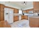 Spacious kitchen with tile floors, white appliances, wood cabinets, and ample counter space at 631 San Pedro Dr, The Villages, FL 32159