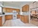 Bright kitchen featuring white appliances, tile flooring, light wood cabinets, and access to the dining room at 631 San Pedro Dr, The Villages, FL 32159